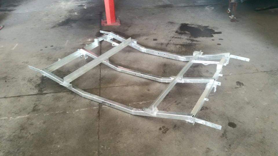 A newly welded aluminium frame lying on the concrete workshop floor.