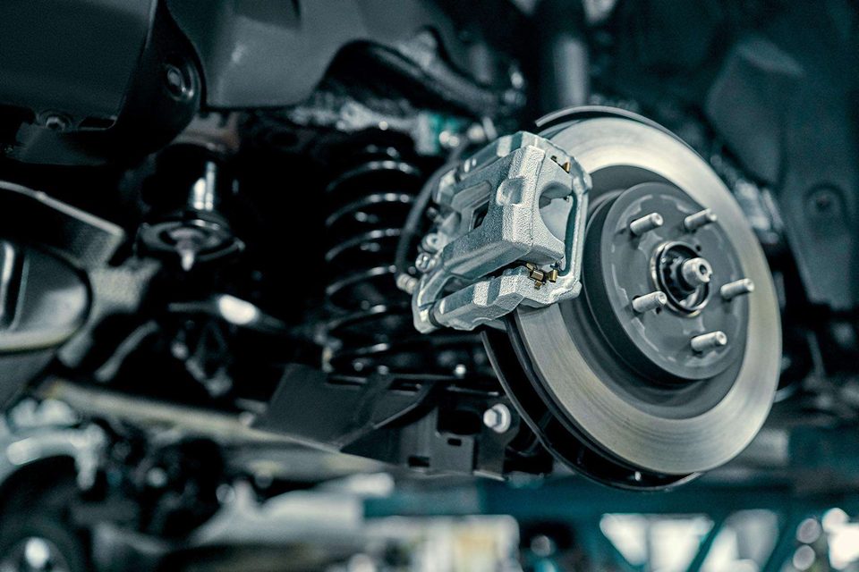 Stock photo: a brake disc and calliper behind a removed wheel on a vehicle hoist.