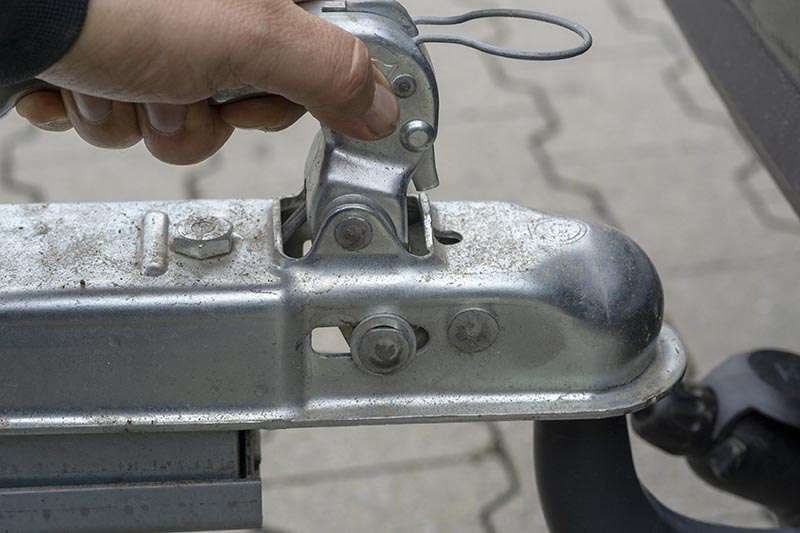 Stock photo: a hand opening a trailer coupling handle.