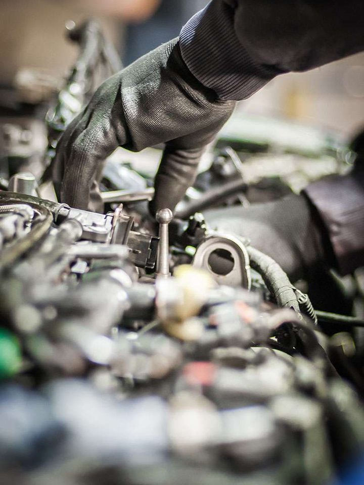 Stock photo: gloved hands working on an engine.