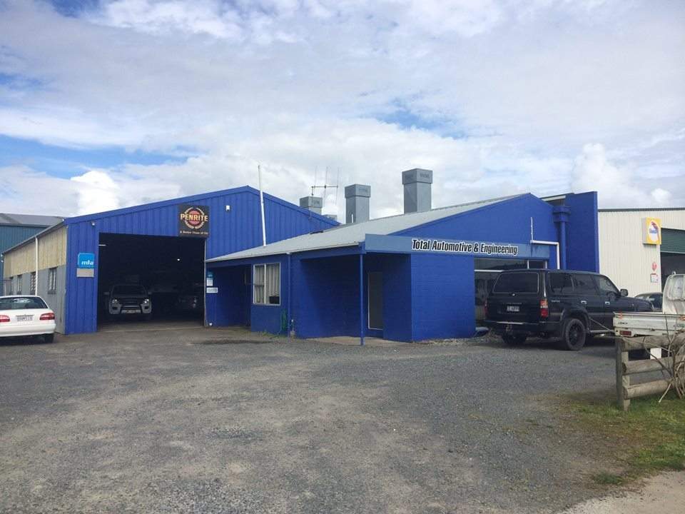 The Total Automotive and Engineering workshop on Bond Road, Te Awamutu: a blue corrugated-iron building with a roller door open and cars parked on the gravel yard.